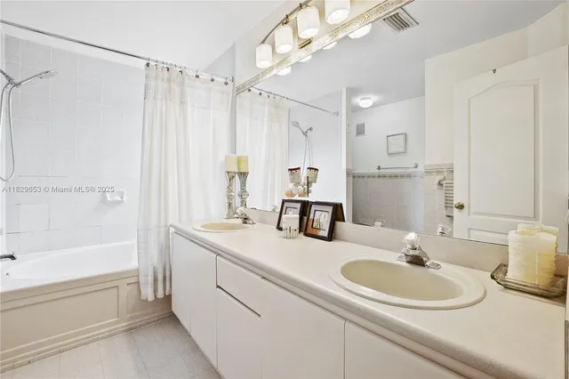 a bathroom with a sink double vanity mirror and a bathtub