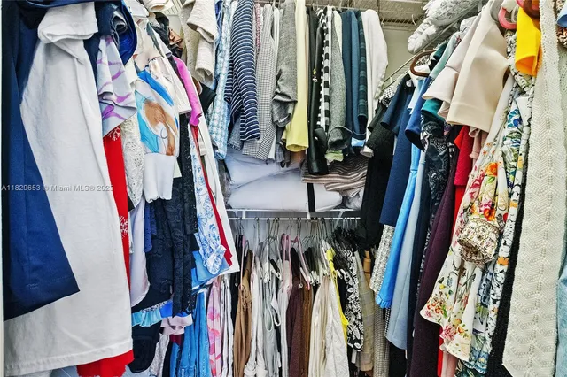 a view of walk in closet with clothes