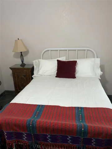 a bedroom with bed and wooden floor