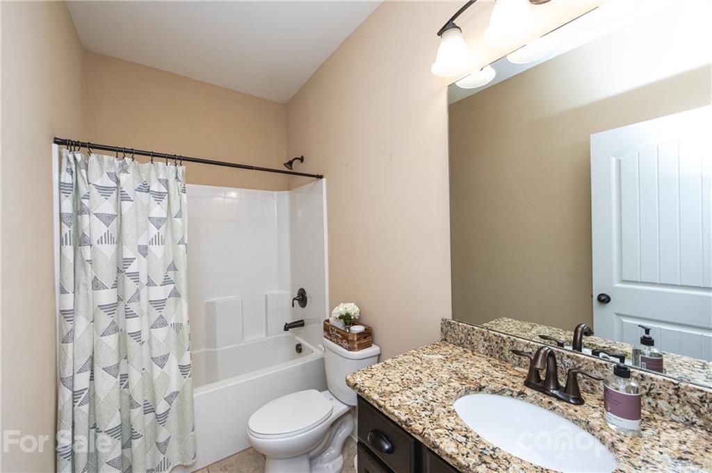 281 Annatto Way Tega Cay, SC 29708 - Photo 21 of 48 a bathroom with a granite countertop sink toilet a mirror and shower