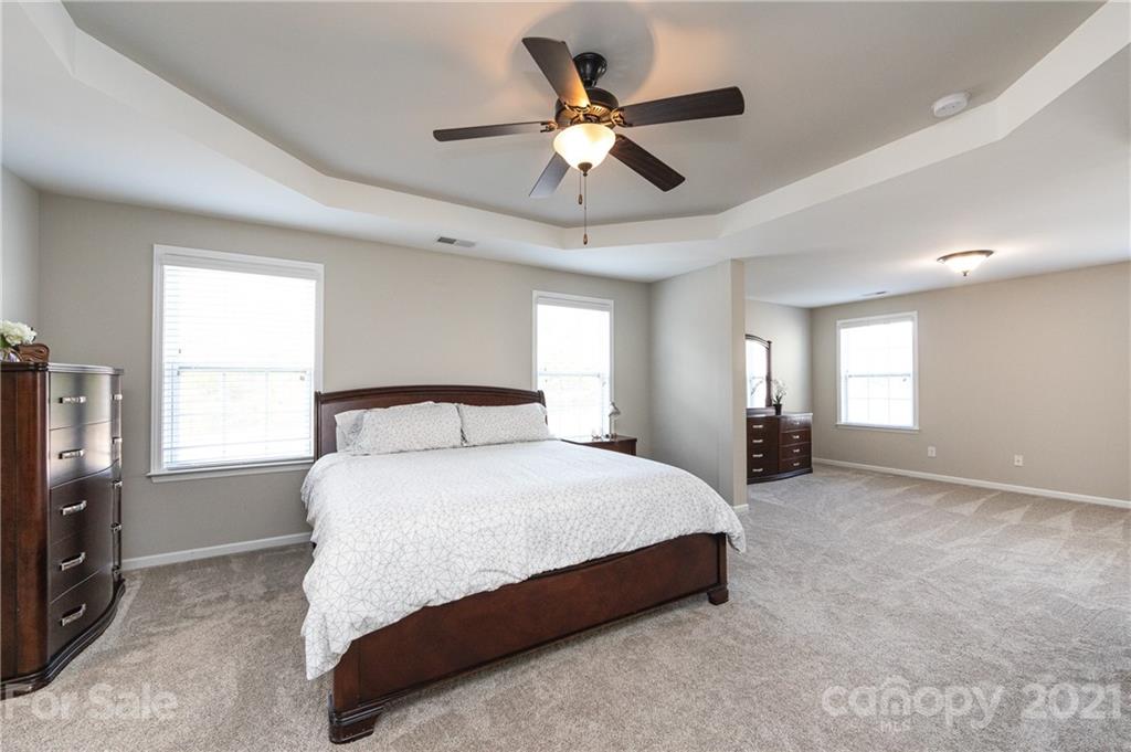 281 Annatto Way Tega Cay, SC 29708 - Photo 26 of 48 a spacious bedroom with a bed chandelier and a window