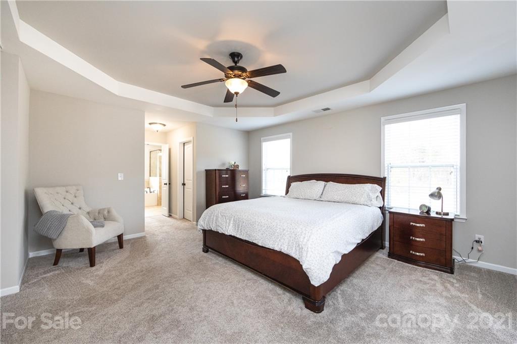 281 Annatto Way Tega Cay, SC 29708 - Photo 27 of 48 a spacious bedroom with a bed and a chandelier