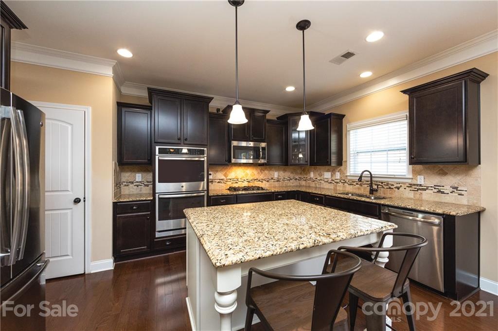 281 Annatto Way Tega Cay, SC 29708 - Photo 5 of 48 a kitchen with stainless steel appliances granite countertop a stove a refrigerator a oven a kitchen island a sink and a refrigerator