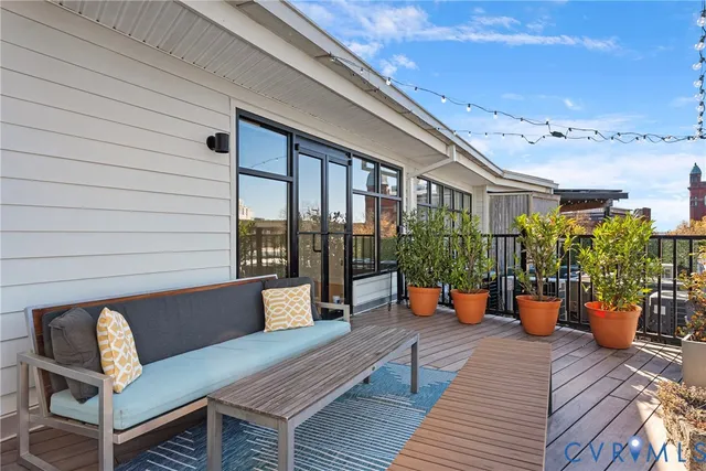 a view of a balcony with wooden floor and seating space