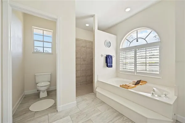 a spacious bathroom with a bathtub a toilet a sink and a window