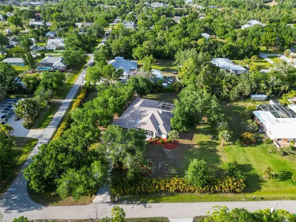 an aerial view of residential houses with outdoor space and trees