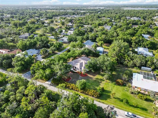 an aerial view of residential houses with outdoor space and trees
