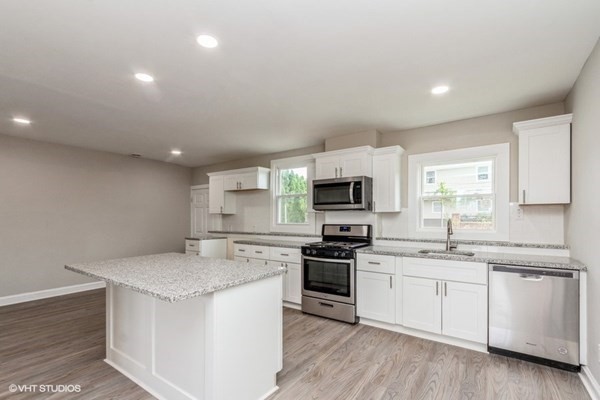 170-180 America Street Fall River, MA 02721 - Photo 26 of 40 a kitchen with granite countertop white cabinets and white appliances