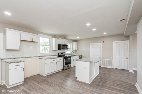 170-180 America Street Fall River, MA 02721 - Photo 28 of 40 a kitchen with white cabinets and stainless steel appliances