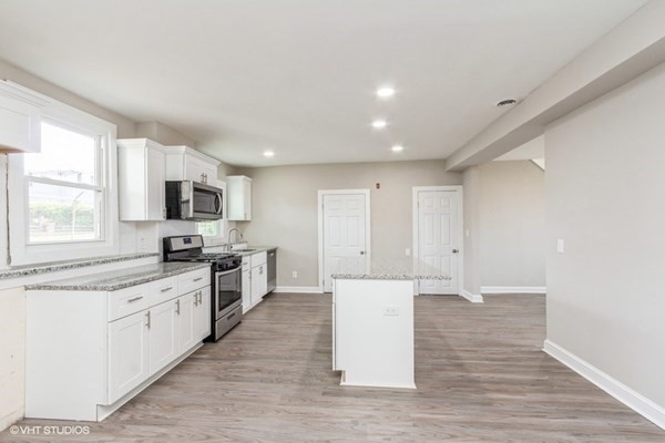 170-180 America Street Fall River, MA 02721 - Photo 29 of 40 a large kitchen with a stove top oven a sink dishwasher and a refrigerator with wooden floor