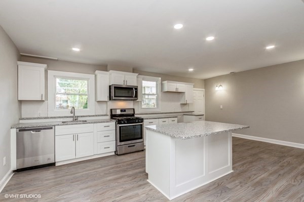170-180 America Street Fall River, MA 02721 - Photo 7 of 40 a large kitchen with stainless steel appliances granite countertop a stove a sink a refrigerator and white cabinets with wooden floor