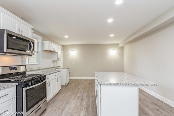 170-180 America Street Fall River, MA 02721 - Photo 8 of 40 a large kitchen with stainless steel appliances granite countertop a stove a sink and a microwave