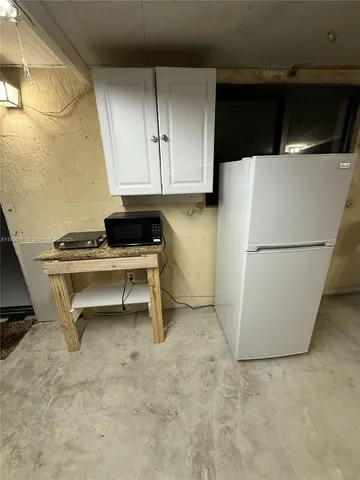 a kitchen with a refrigerator and a stove top oven