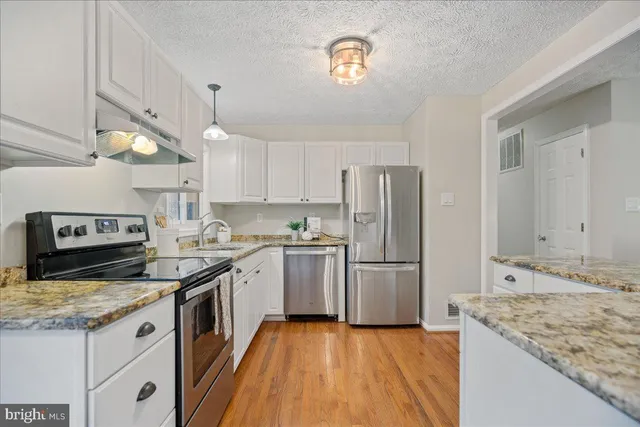 a kitchen with a stove a sink and a refrigerator