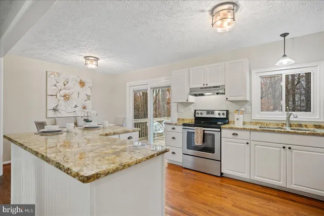 a kitchen with stainless steel appliances granite countertop a stove and a sink