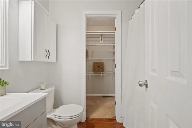 a bathroom with a granite countertop toilet a sink and a bathtub