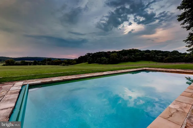 a view of a house with a big yard and large trees