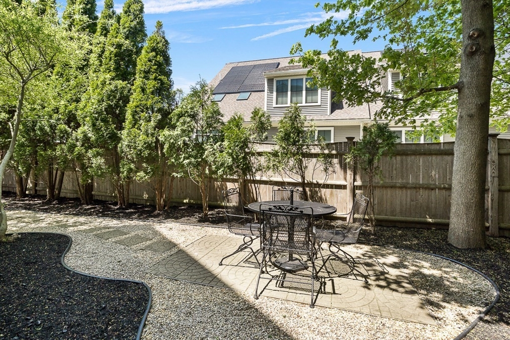7 Sherman Place, Unit 7 Winchester, MA 01890 - Photo 38 of 40 a view of a patio with a table and chairs and potted plants