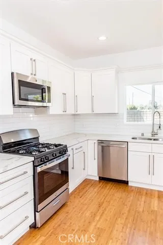 a kitchen with granite countertop a stove top oven microwave and cabinets