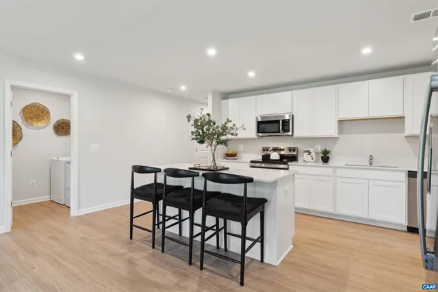 a kitchen that has a sink a stove and cabinets