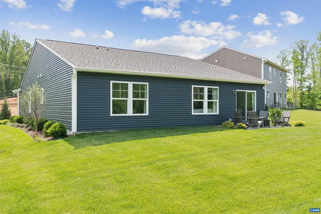 a view of a house with backyard and sitting area
