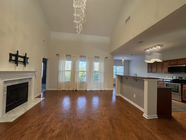 a view of kitchen with microwave a stove and wooden floor