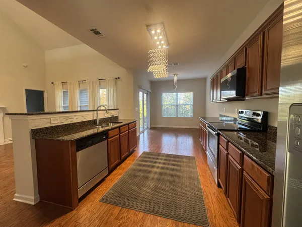 a large kitchen with stainless steel appliances granite countertop a stove and a sink