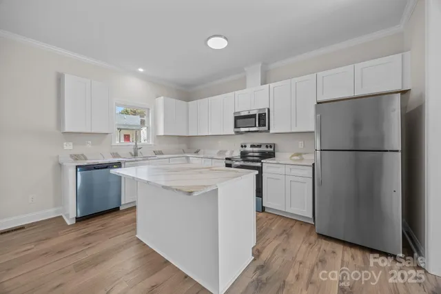 a kitchen with a refrigerator stove and wooden cabinets