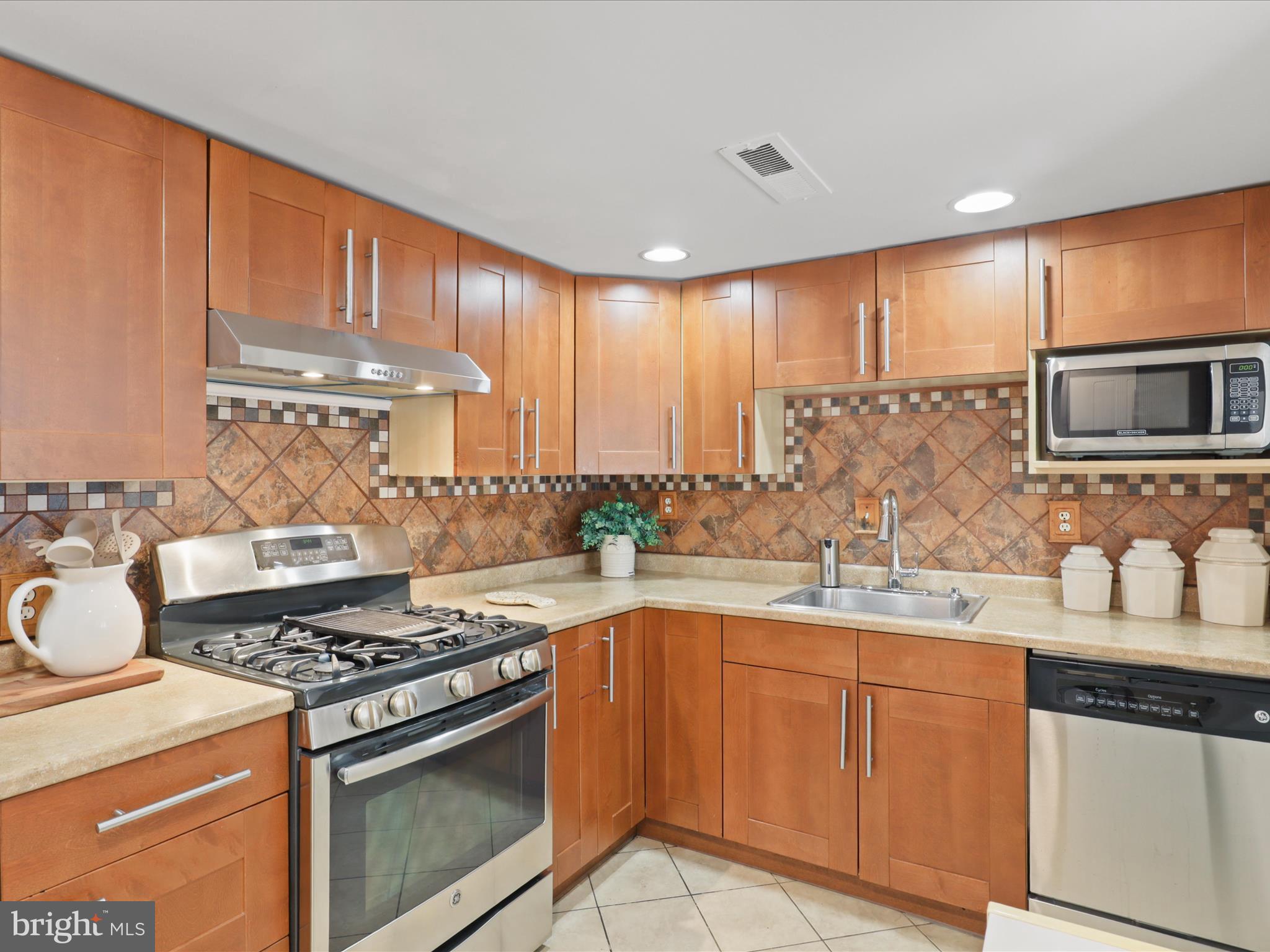 246 Stevenson Square Alexandria, VA 22304 - Photo 7 of 31 a kitchen with stainless steel appliances a sink stove and cabinets