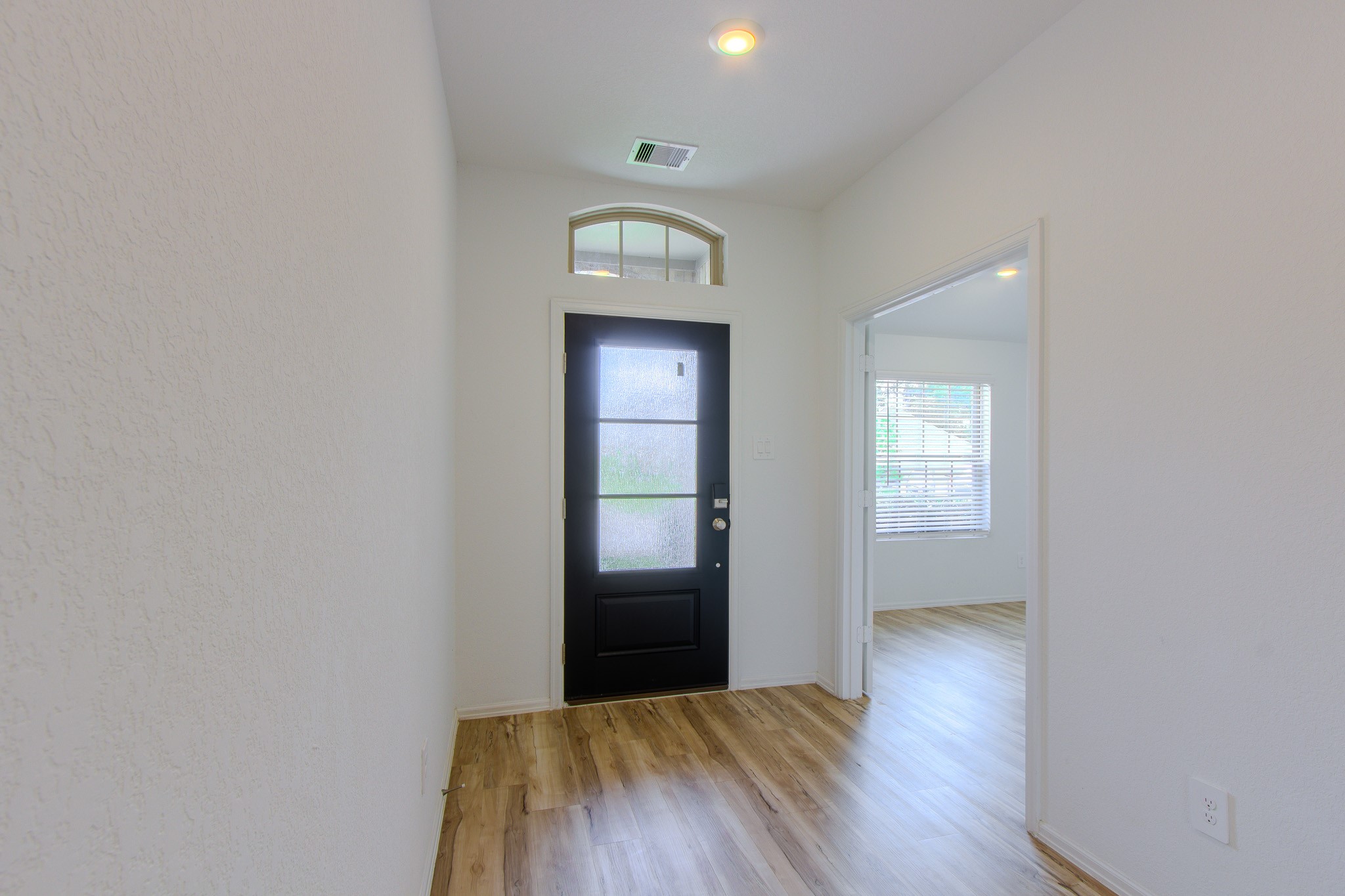 3113 Catalonion Court Conroe, TX 77301 - Photo 5 of 45 a view of a hallway with wooden floor and a bathroom