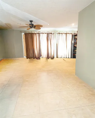 a spacious bedroom with a bed couch and window
