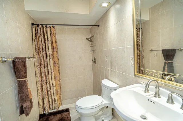 a white toilet sitting next to a shower curtain