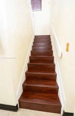 a bedroom with a bed and a dresser next to a window