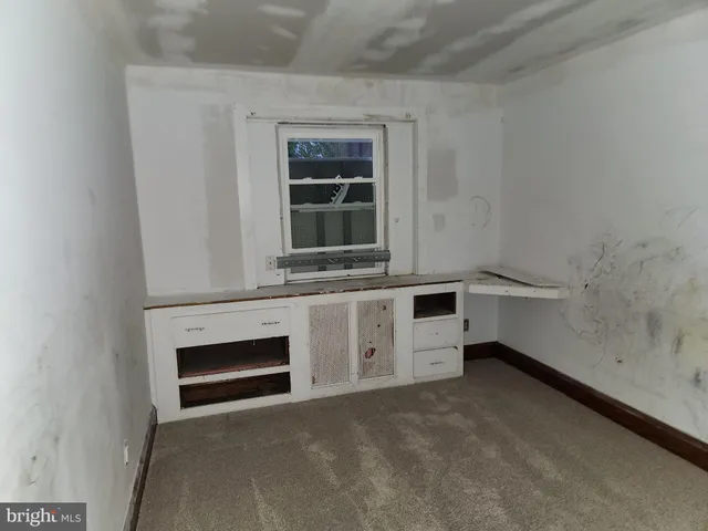 a view of empty room with a fireplace and window
