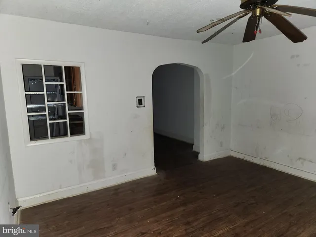a view of empty room with wooden floor and windows