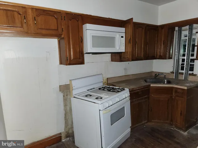 a kitchen with sink cabinets and a stove top oven