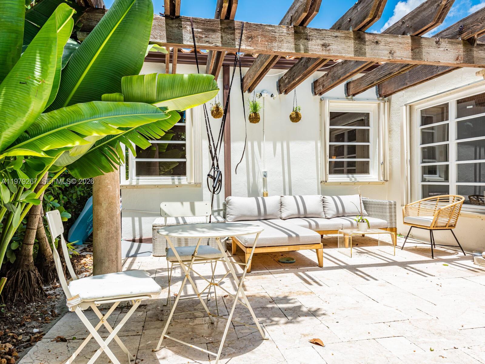 8927 Hawthorne Avenue Surfside, FL 33154 - Photo 11 of 40 a view of a patio with a table and chairs and couches with wooden fence