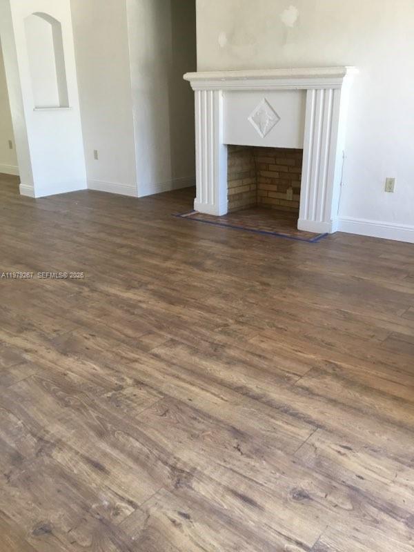 8927 Hawthorne Avenue Surfside, FL 33154 - Photo 18 of 40 a view of empty room with wooden floor and a fireplace