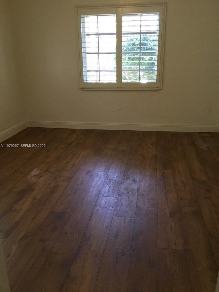 8927 Hawthorne Avenue Surfside, FL 33154 - Photo 24 of 40 an empty room with wooden floor and windows