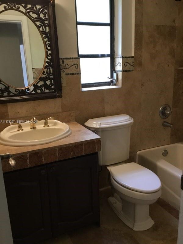 8927 Hawthorne Avenue Surfside, FL 33154 - Photo 25 of 40 a bathroom with a sink a toilet and mirror