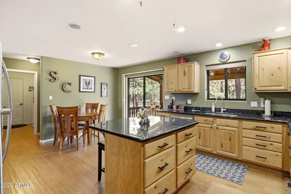 a kitchen with white cabinets and wooden floor