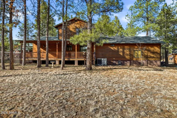 a view of a house with backyard and a tree