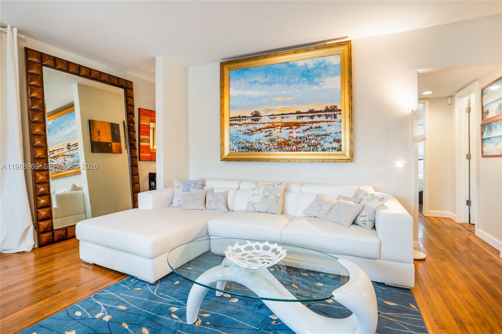 a living room with furniture and a painting on the wall