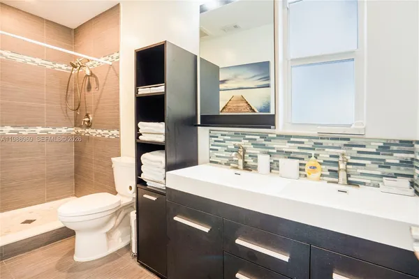 a bathroom with a sink toilet tub and shower