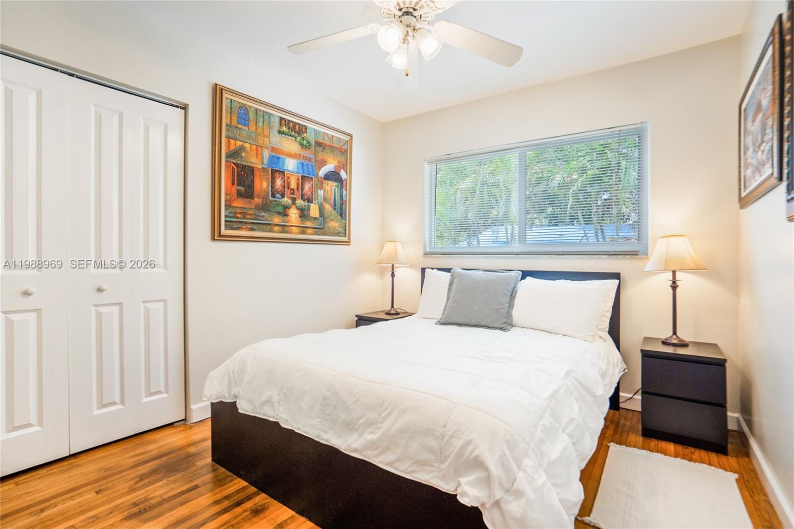 113 Southwest 2nd Street Hallandale Beach, FL 33009 - Photo 27 of 50 a bedroom with a bed and wooden floor