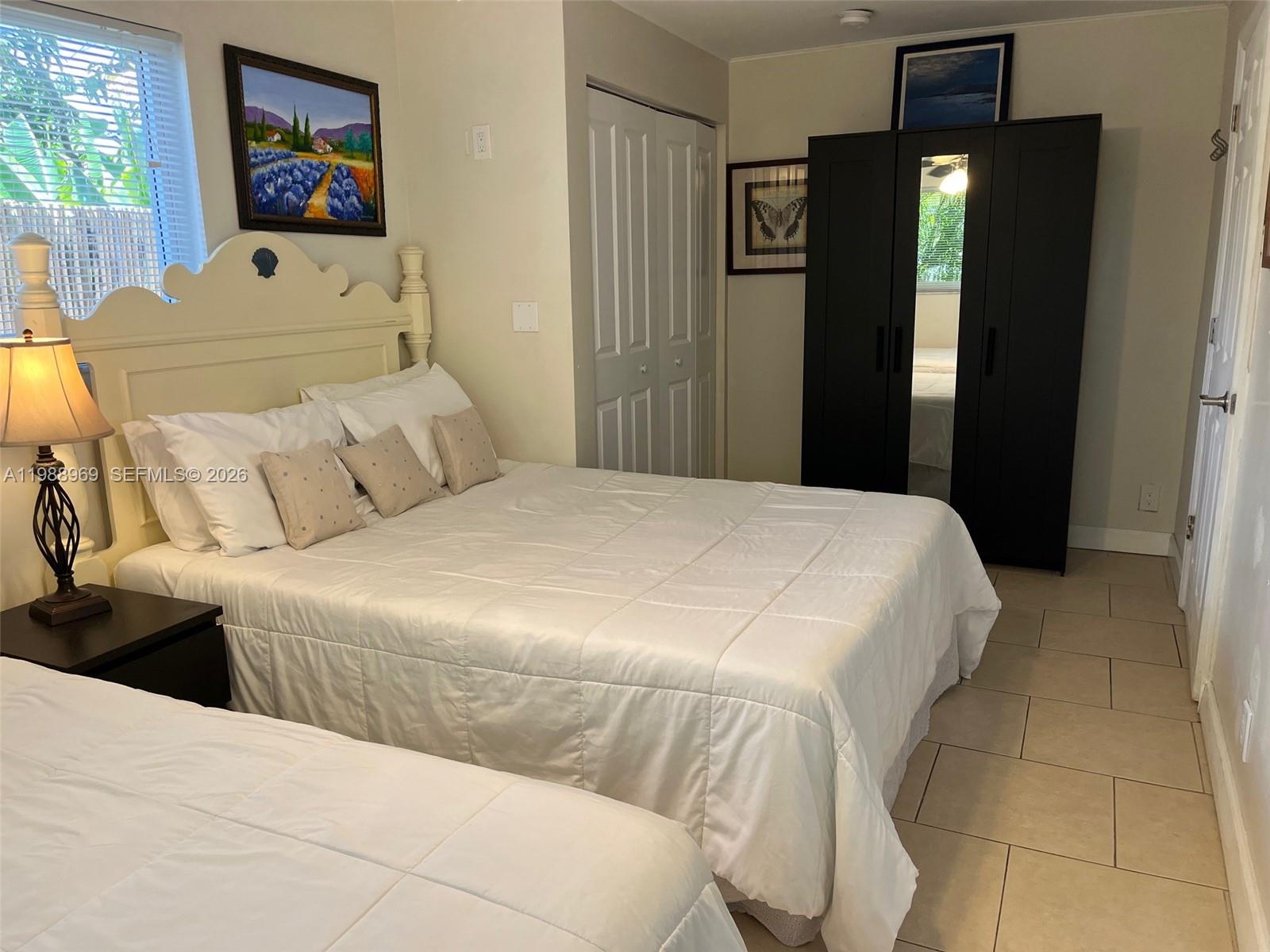 113 Southwest 2nd Street Hallandale Beach, FL 33009 - Photo 32 of 50 a bedroom with a bed and a mirror