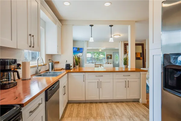 a kitchen with stainless steel appliances granite countertop a refrigerator and a stove top oven