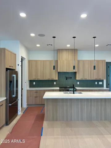 a large kitchen with granite countertop a large counter top stainless steel appliances and cabinets