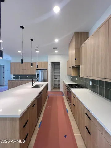 a large kitchen with stainless steel appliances kitchen island granite countertop a lot of counter space and wooden floor