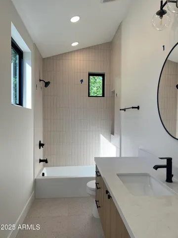 a bathroom with a tub a sink and mirror